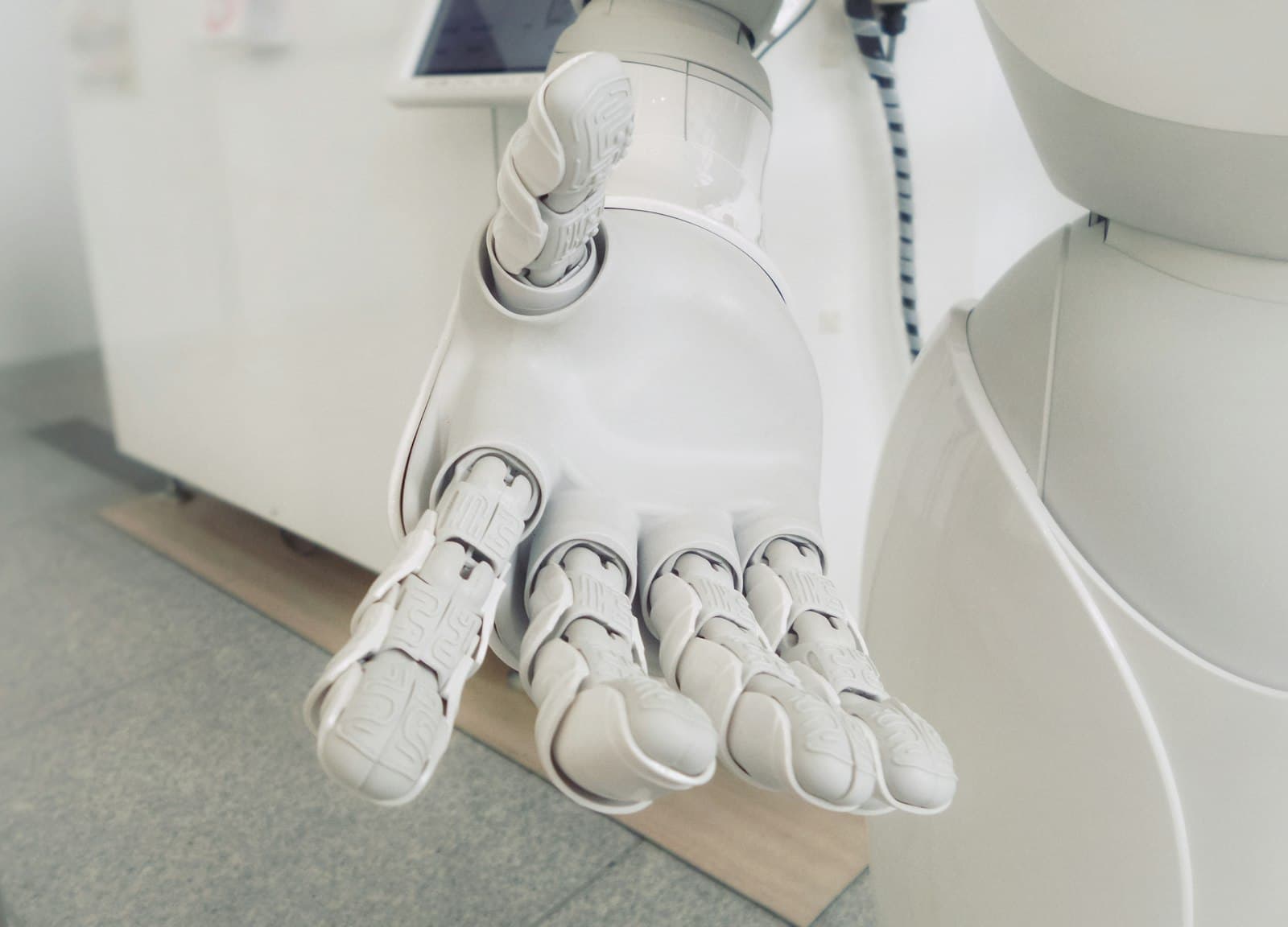 Main d'un robot humanoïde blanc tendue en avant, symbole des assistants d'intelligence artificielle