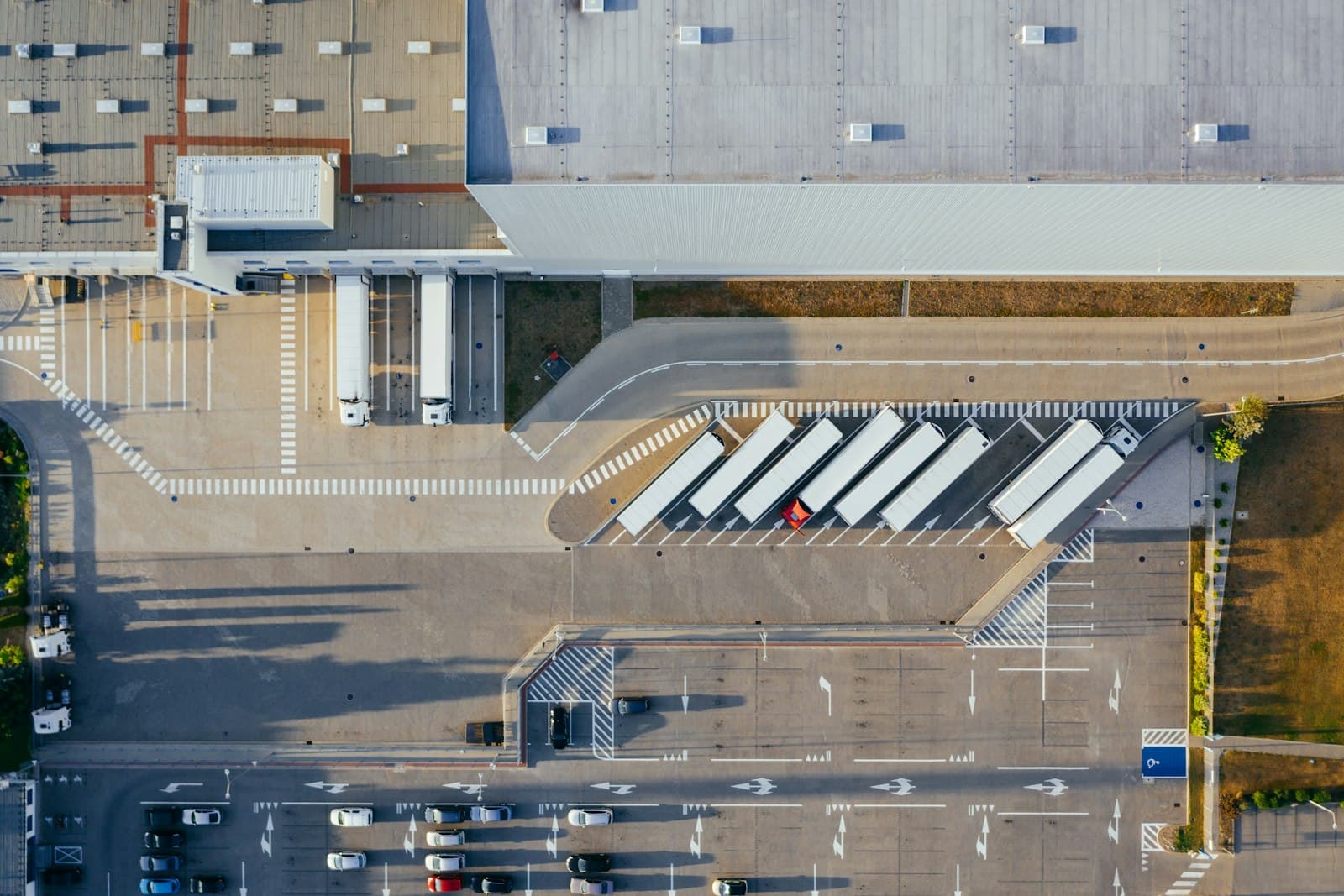 Vue aérienne d'une plateforme logistique, avec des semi-remorques alignées devant les quais de chargement