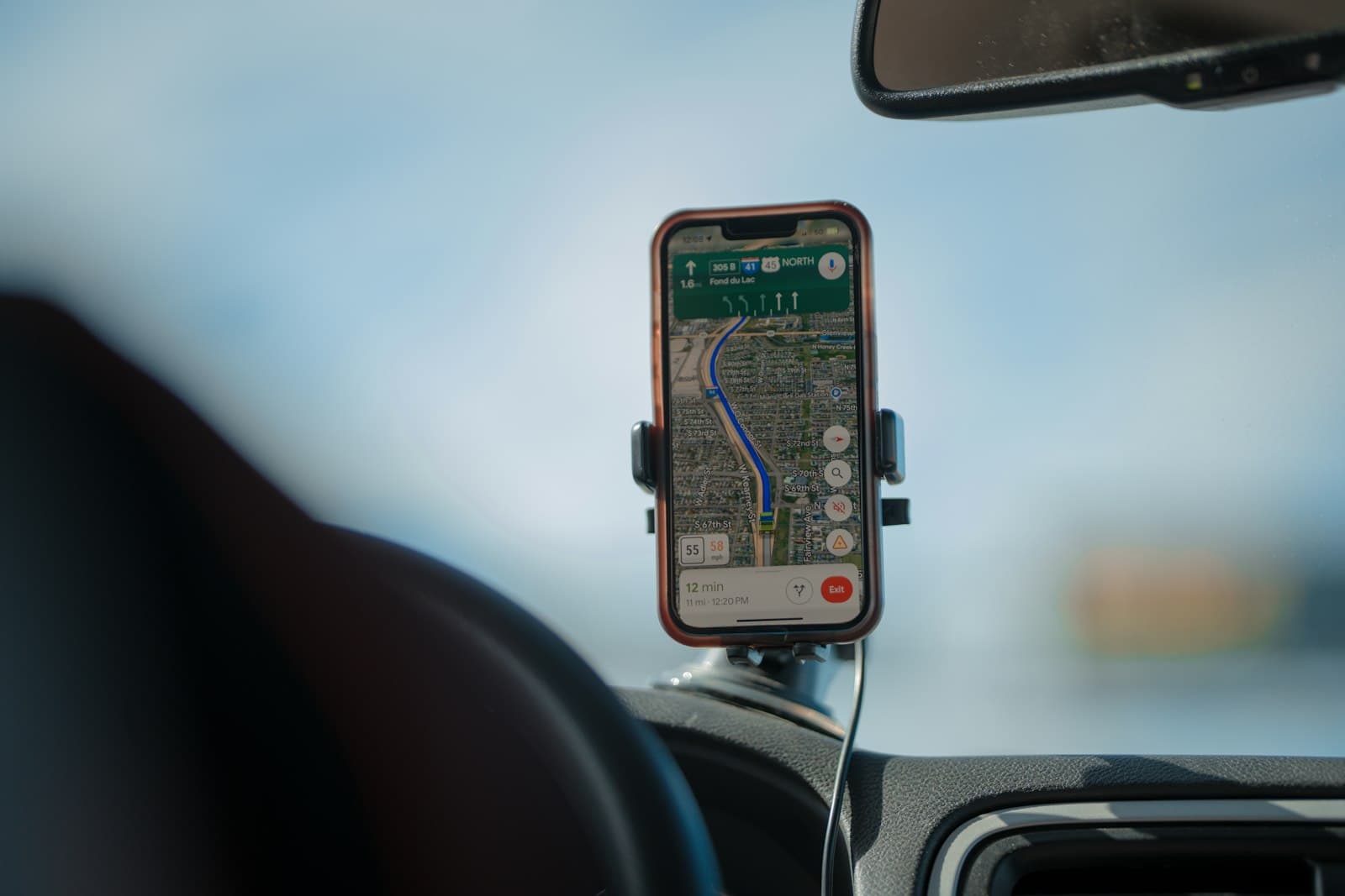 Un smartphone fixé au pare-brise d'un véhicule affiche un itinéraire de navigation