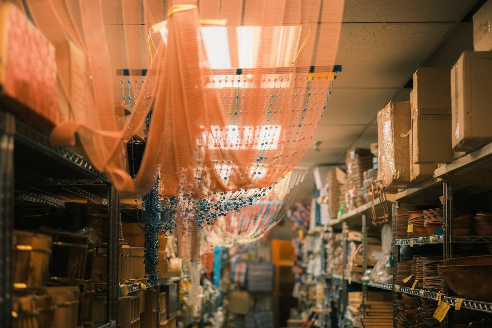 Réserve d'un magasin avec des étagères métalliques chargées de cartons et de marchandises étiquetées