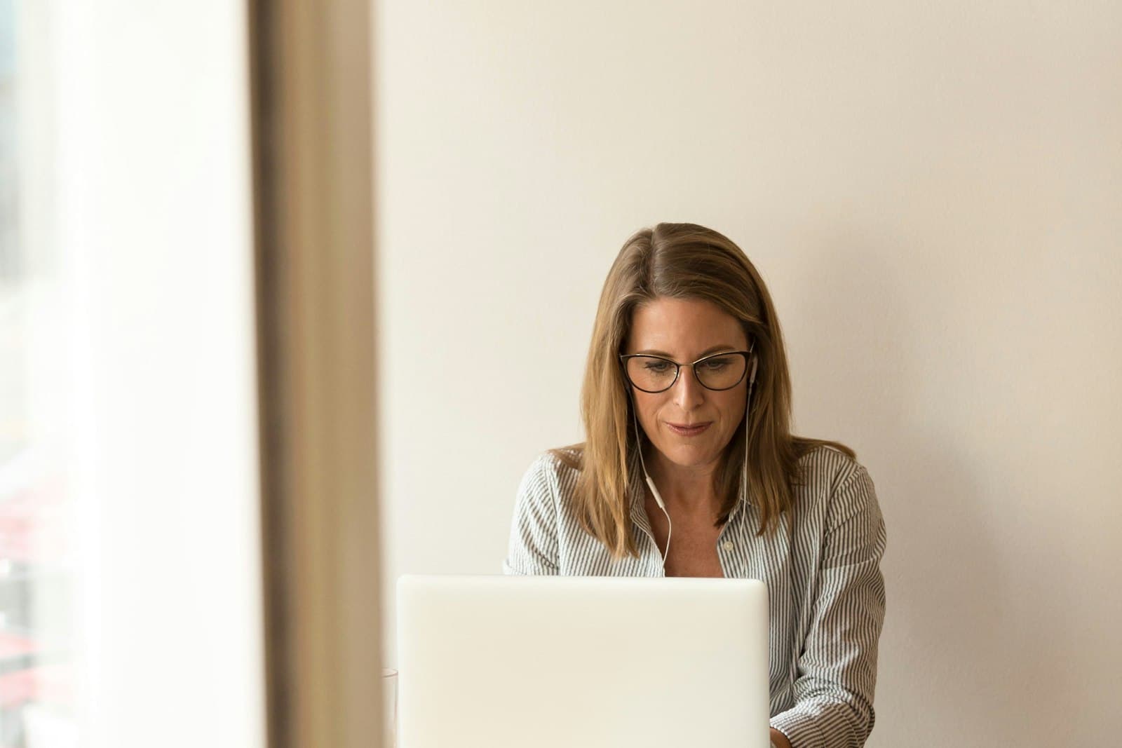 Une dirigeante de petite entreprise travaille sur son ordinateur portable dans un bureau clair