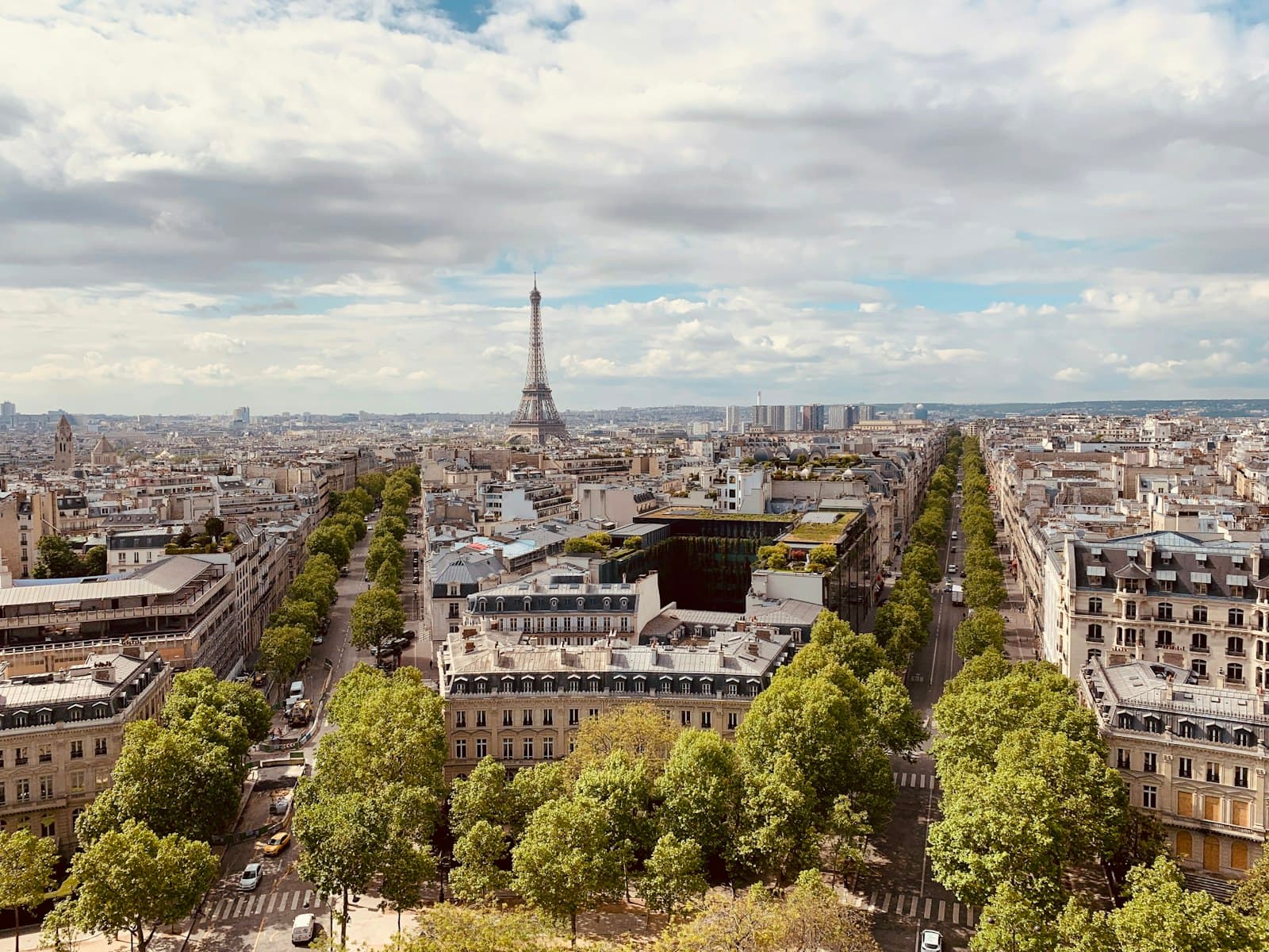 Vue des toits de Paris depuis les hauteurs, avec la tour Eiffel à l'horizon